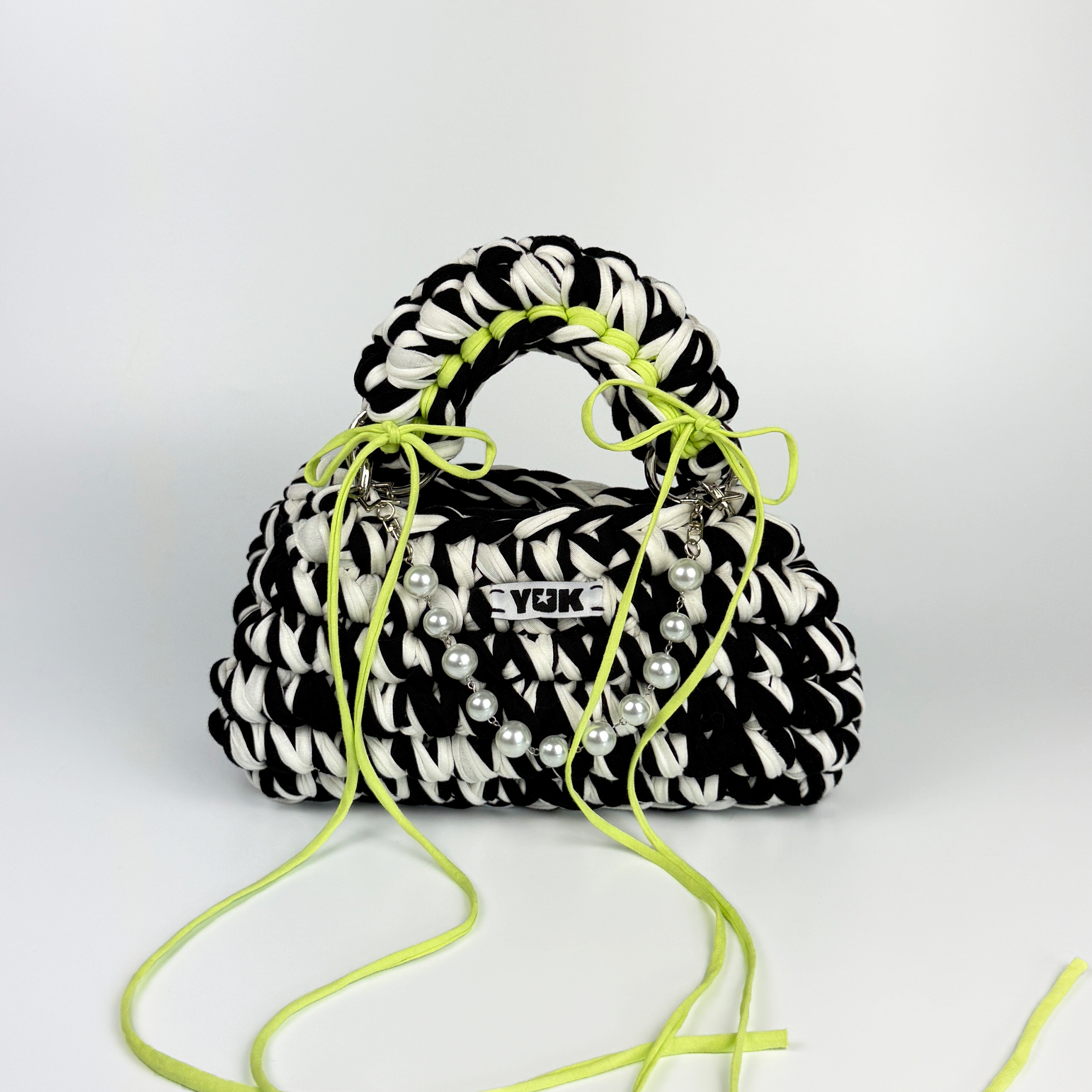 Handmade crochet handbag in black and white with a bag charm by Studio YUK