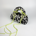 Handmade crochet handbag in black and white with a bag charm by Studio YUK