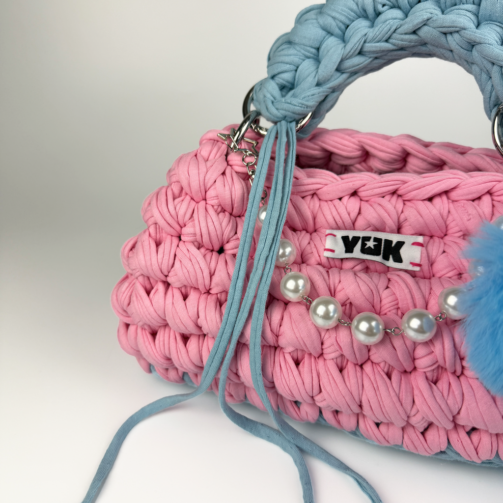 Handmade crochet handbag in pink and blue with a bag charm by Studio YUK