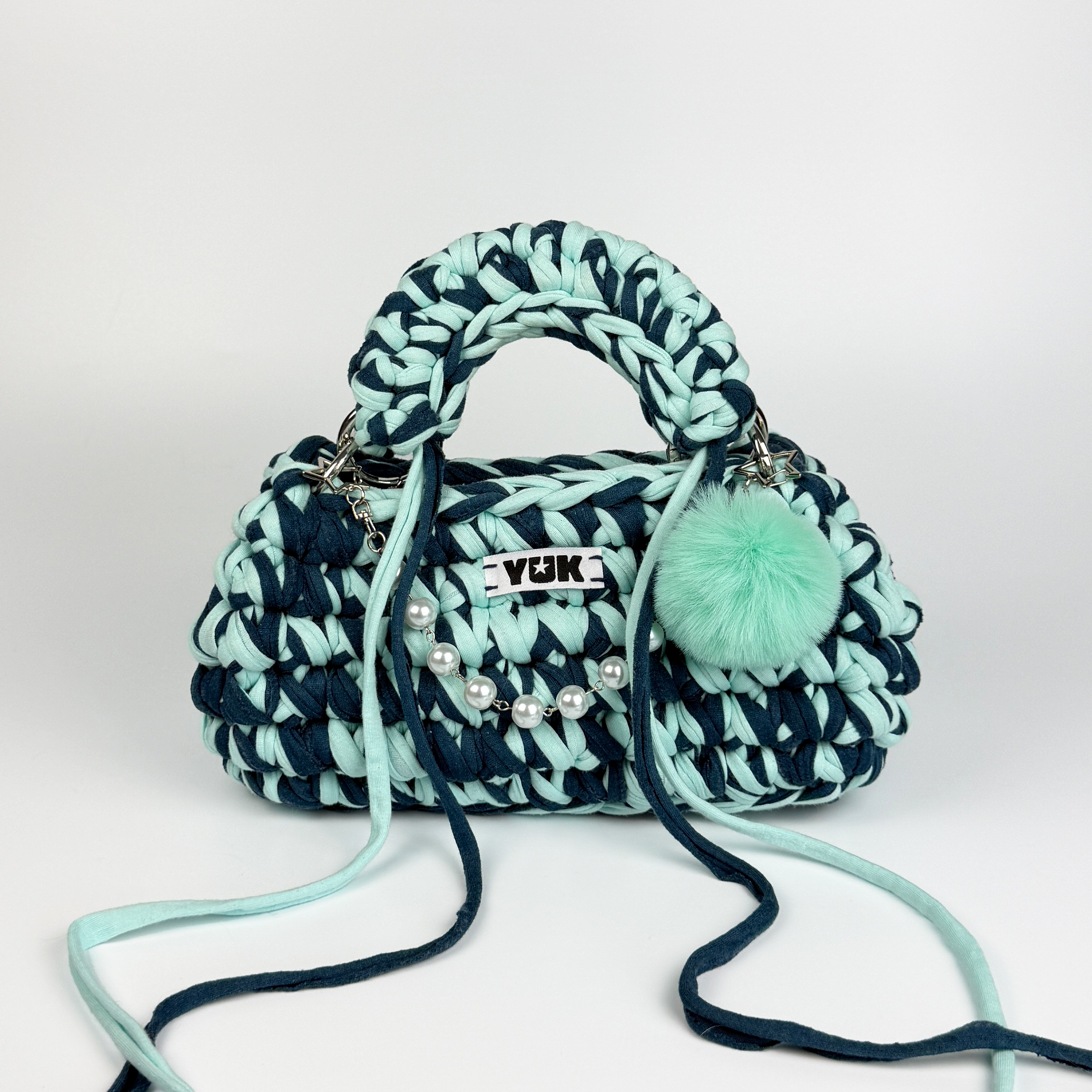 Handmade crochet handbag in blue with a bag charm by Studio YUK