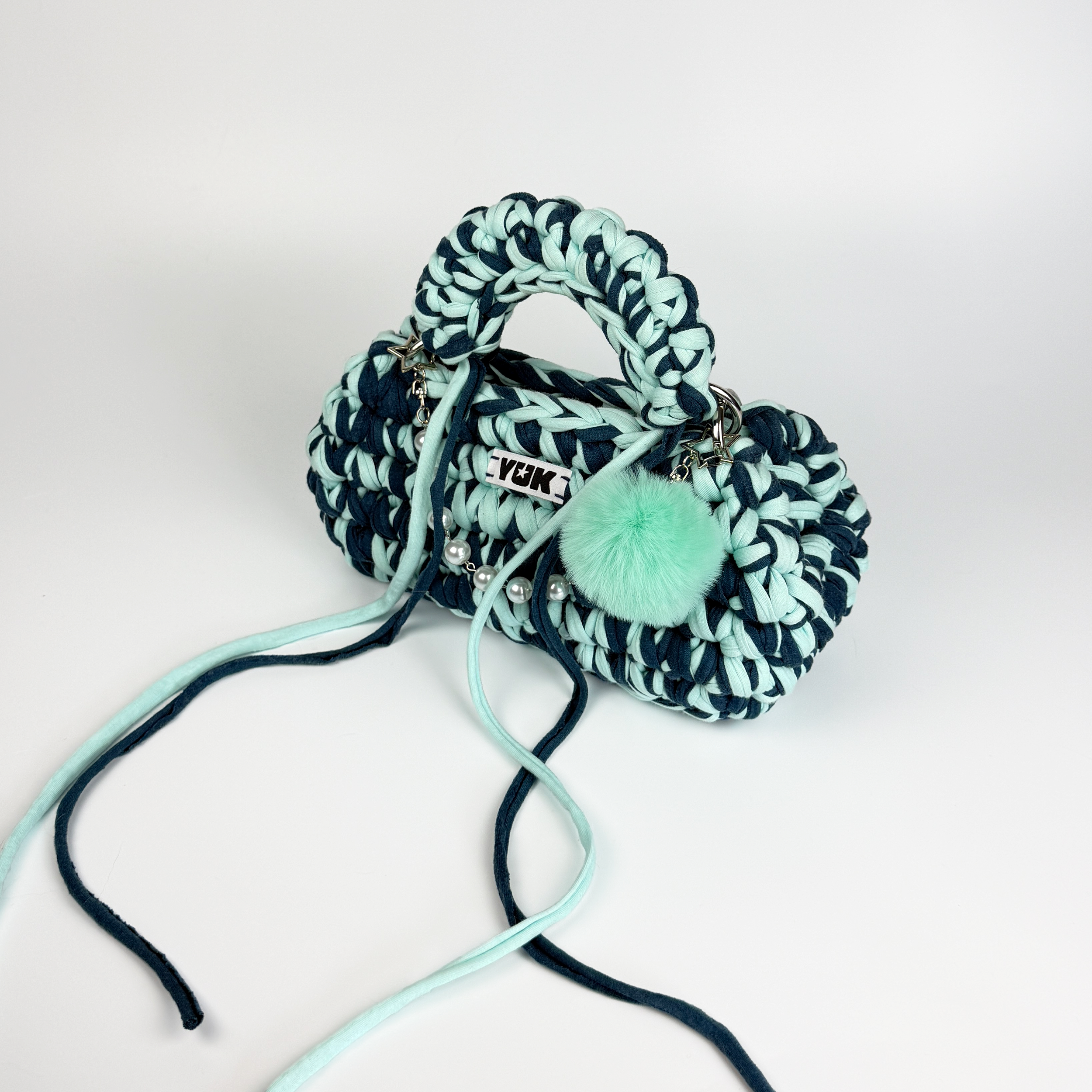 Handmade crochet handbag in blue with a bag charm by Studio YUK