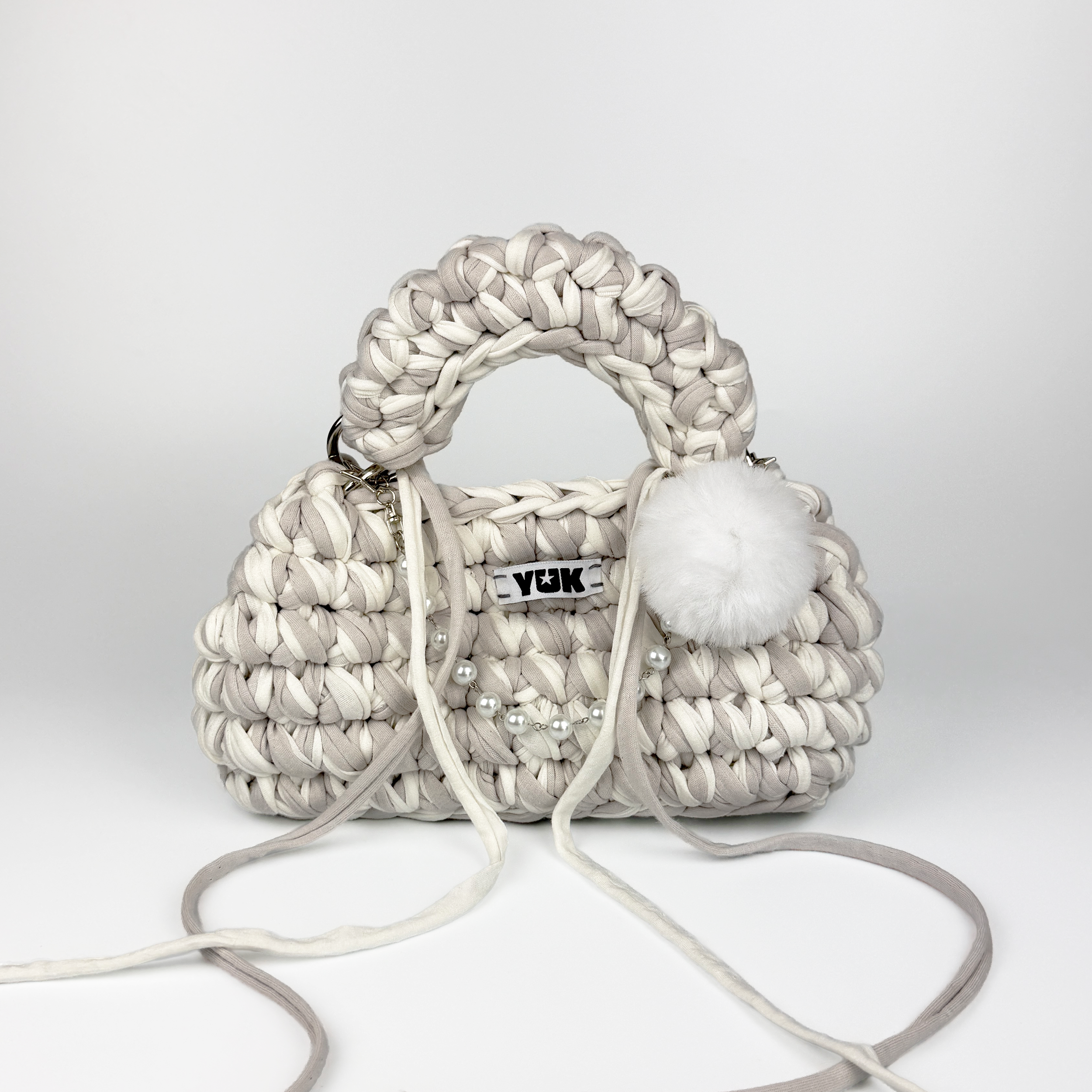 Handmade crochet handbag in white and grey with a bag charm by Studio YUK
