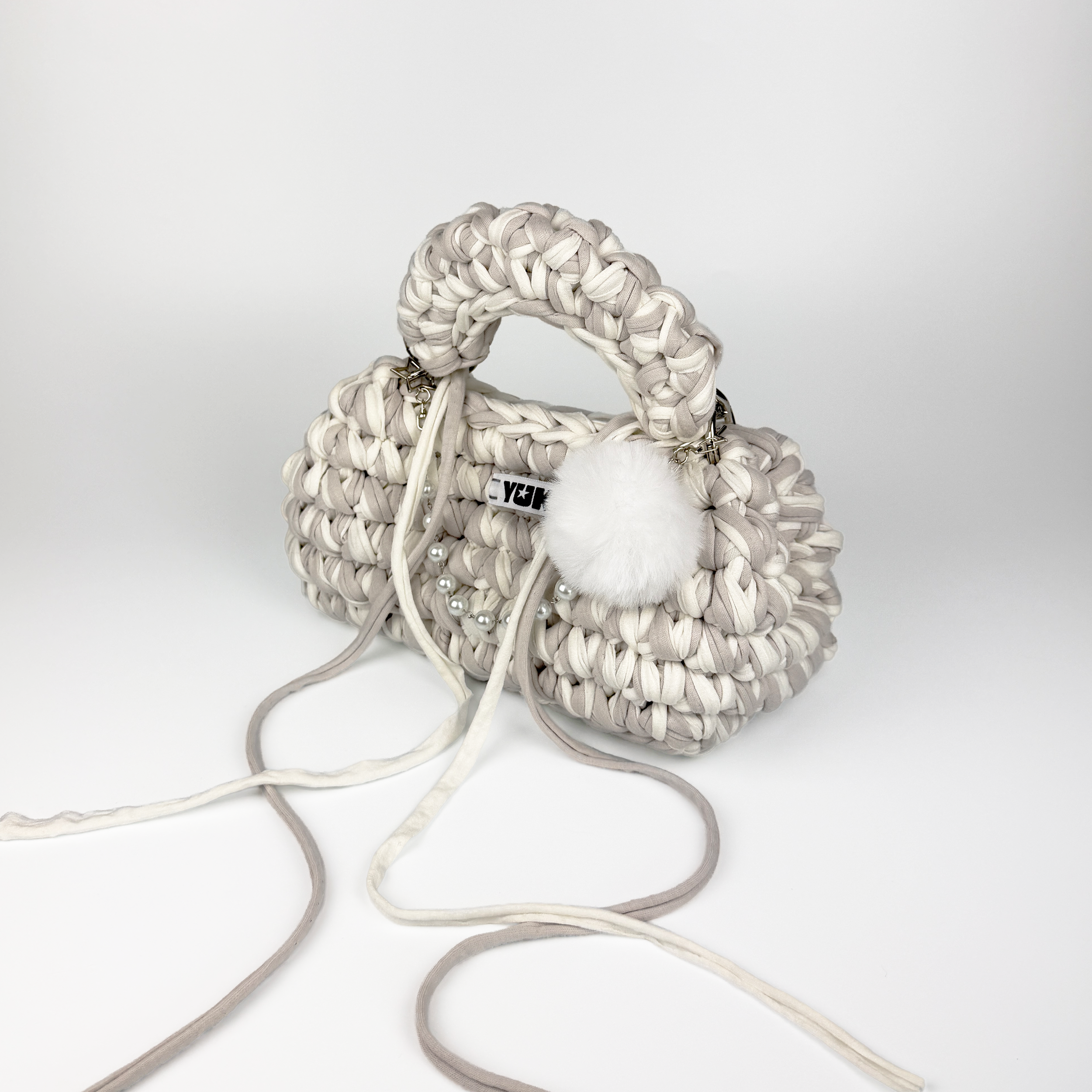 Handmade crochet handbag in white and grey with a bag charm by Studio YUK