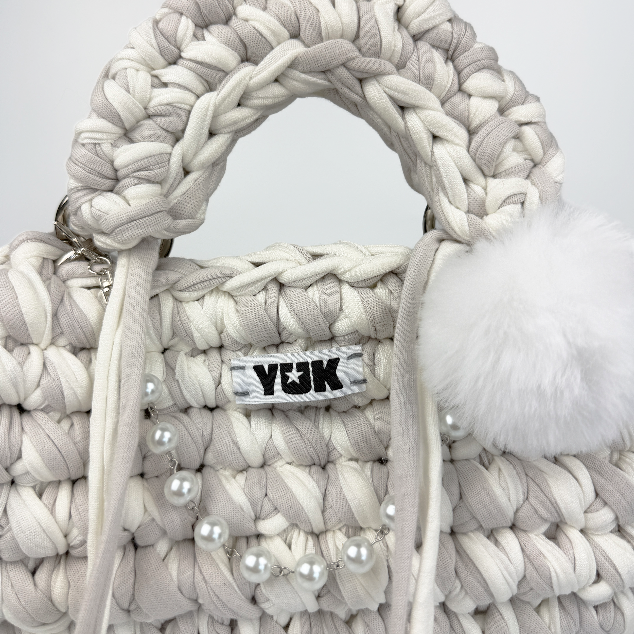 Handmade crochet handbag in white and grey with a bag charm by Studio YUK