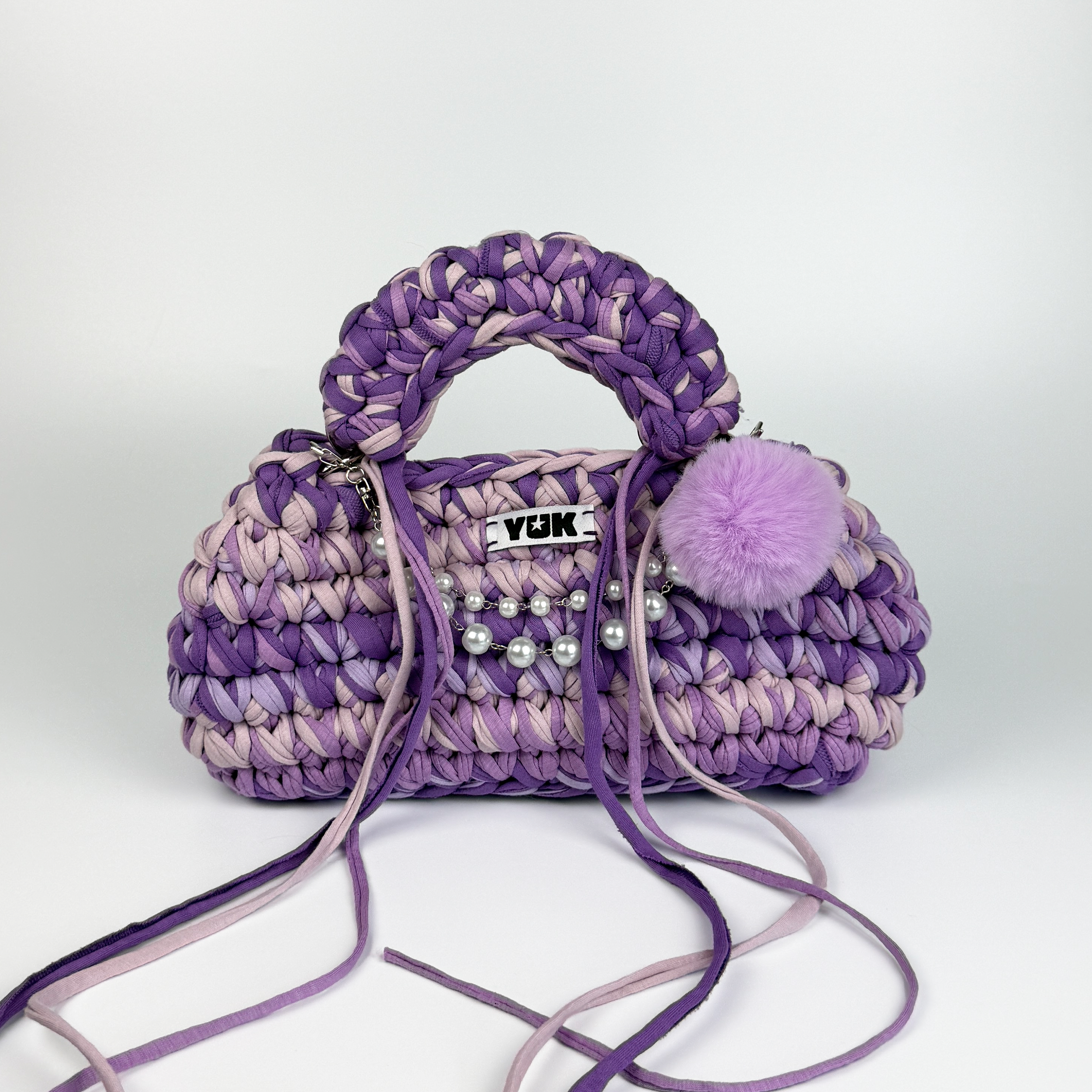 Handmade crochet handbag in purple and lilac with a bag charm by Studio YUK