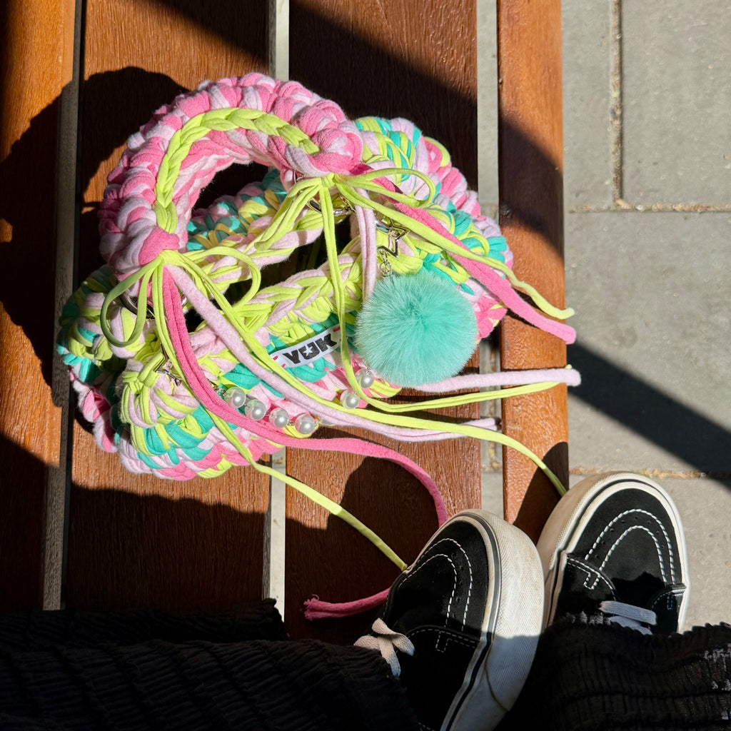 Lifestyle image featuring the rainbow colored Studio YUK crochet handbag