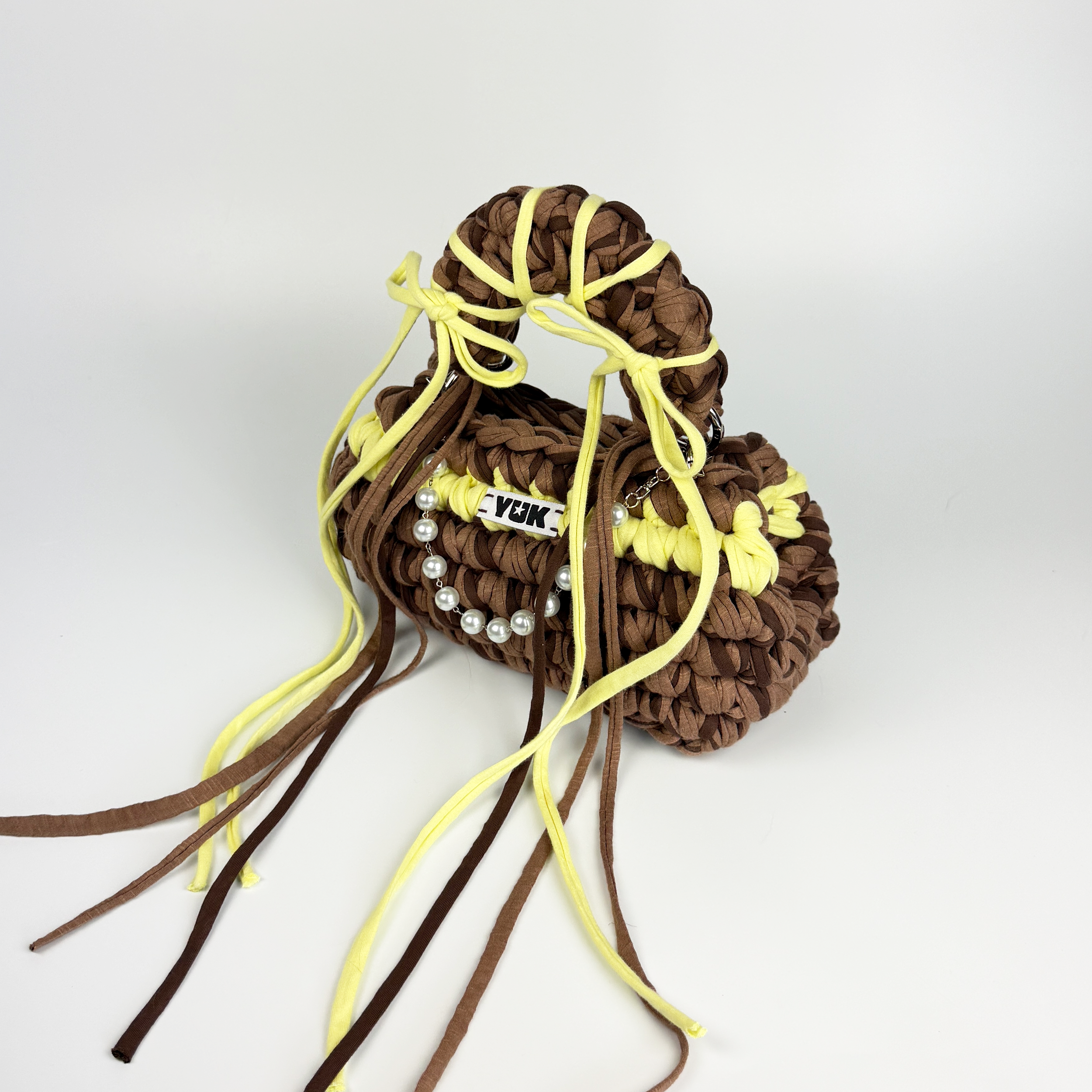 Handmade crochet handbag in brown and yellow with a bag charm by Studio YUK