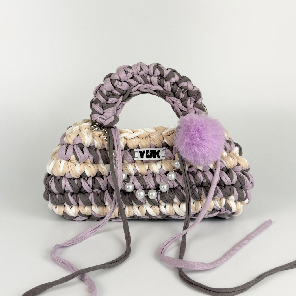 Handmade crochet handbag in lilac, purple, grey, white and beige with a bag charm by Studio YUK