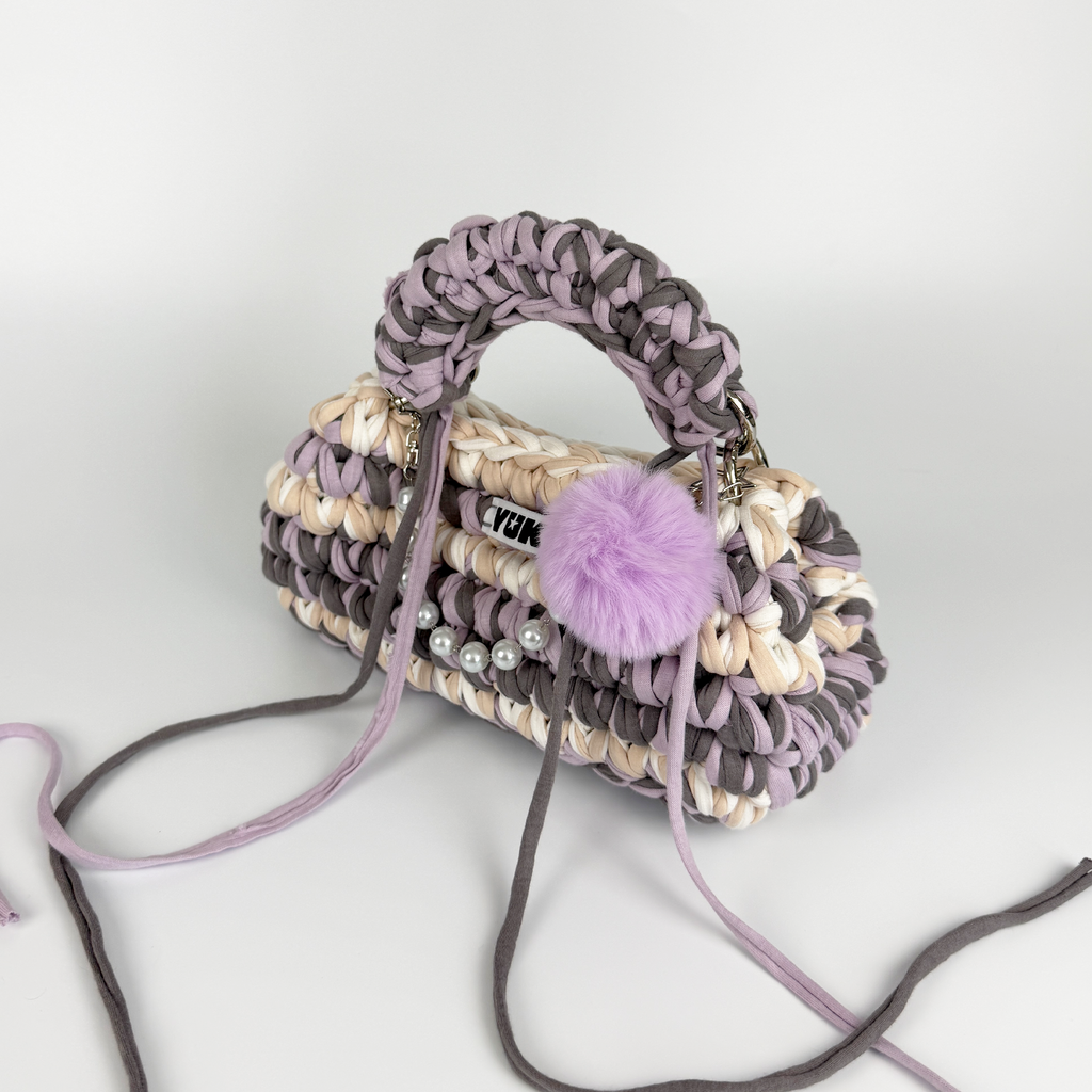 Handmade crochet handbag in lilac, purple, grey, white and beige with a bag charm by Studio YUK
