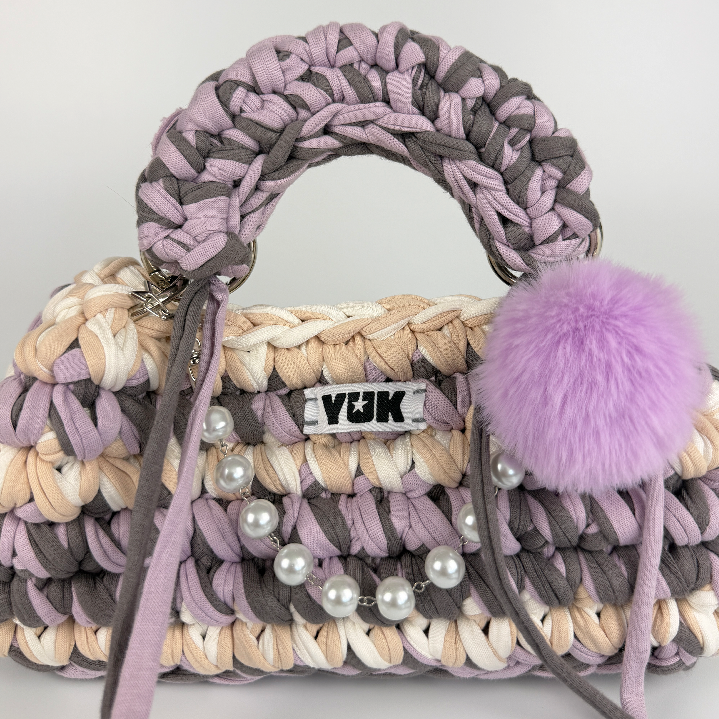 Handmade crochet handbag in lilac, purple, grey, white and beige with a bag charm by Studio YUK
