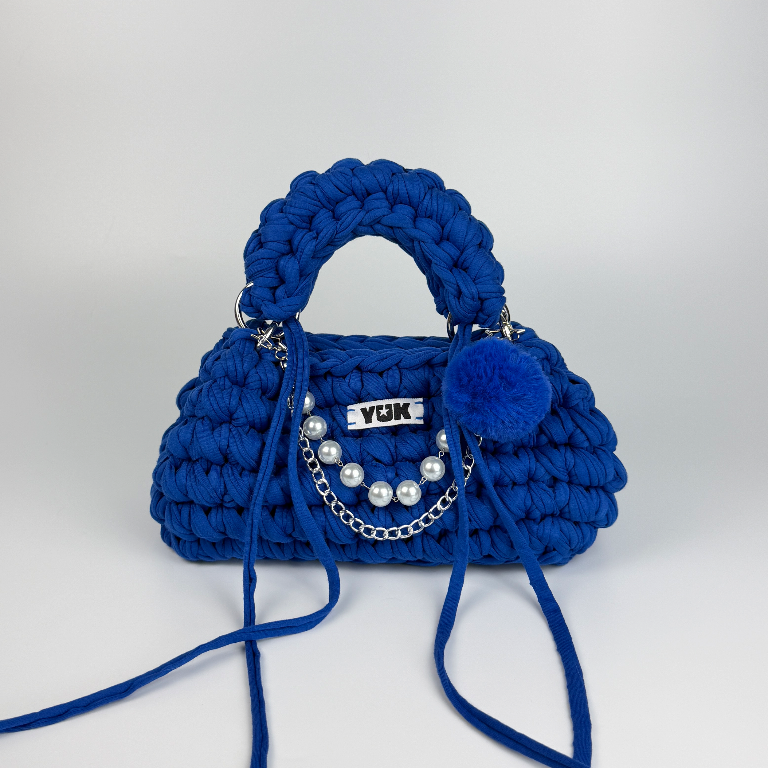 Handmade crochet handbag in blue with a bag charm by Studio YUK