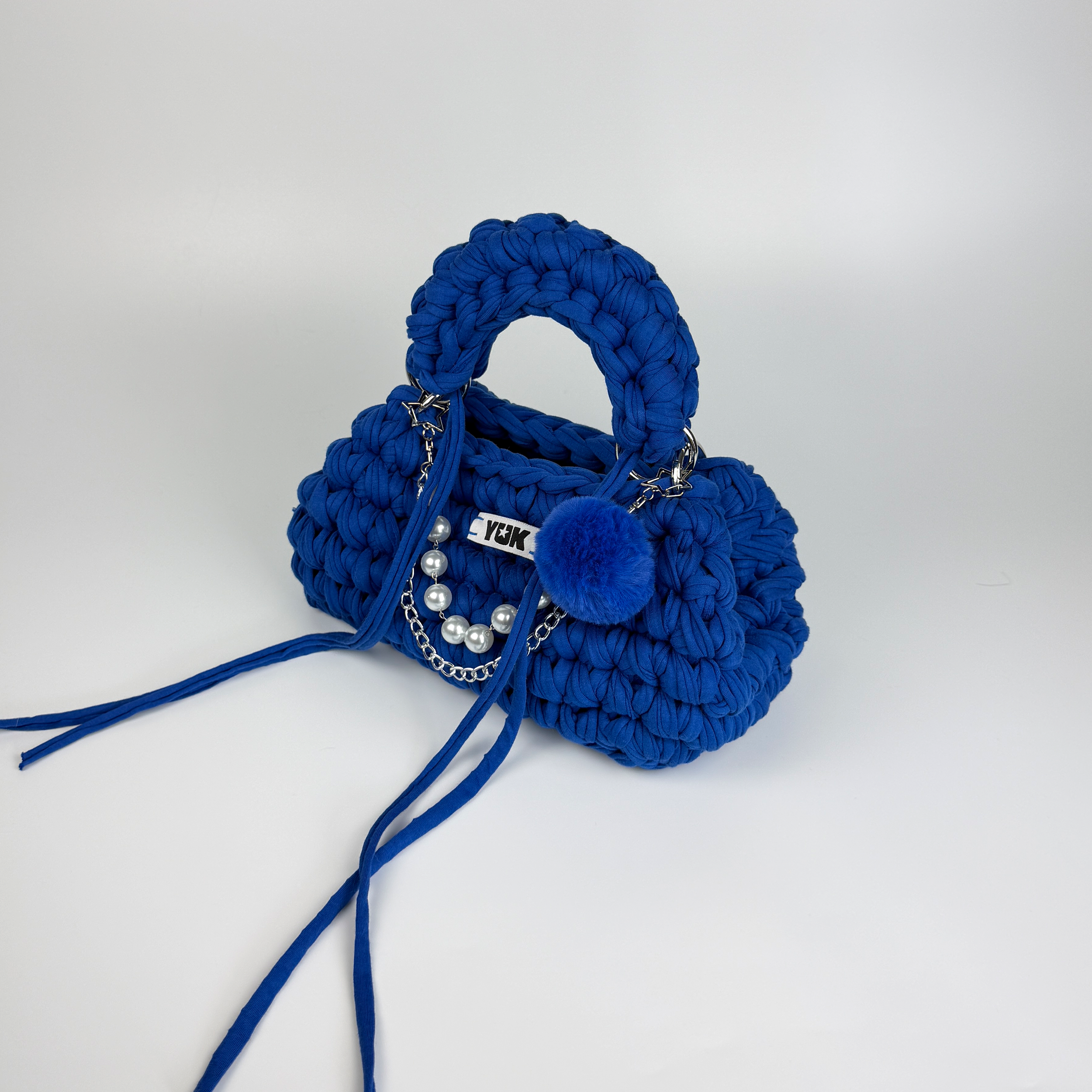 Handmade crochet handbag in blue with a bag charm by Studio YUK