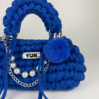Handmade crochet handbag in blue with a bag charm by Studio YUK
