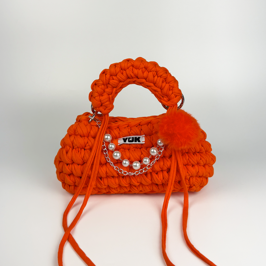 Handmade crochet handbag in oraneg with a bag charm by Studio YUK