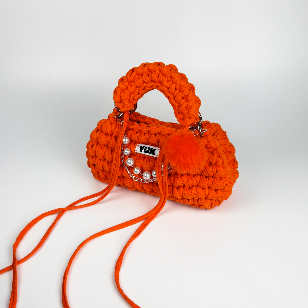 Handmade crochet handbag in oraneg with a bag charm by Studio YUK