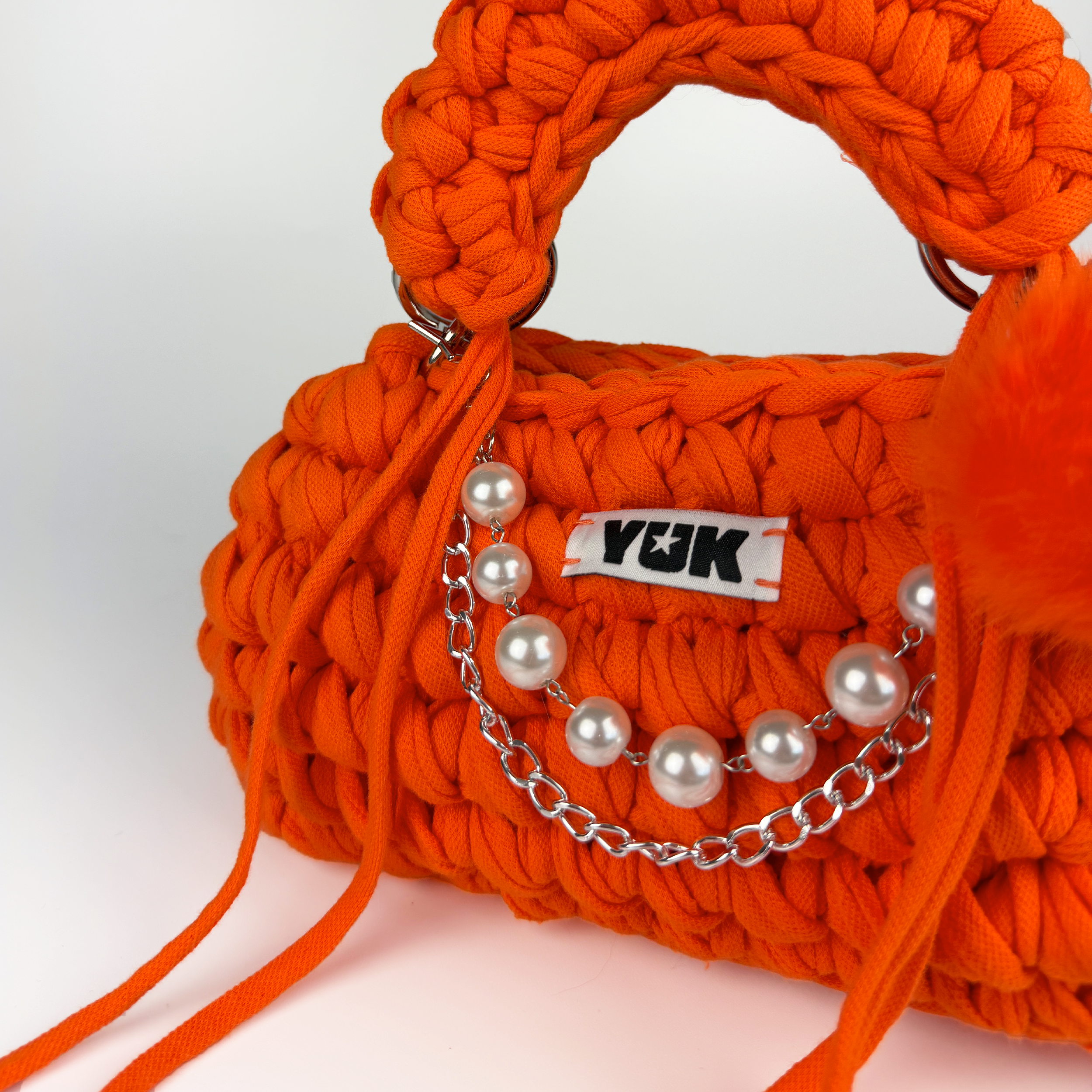 Handmade crochet handbag in oraneg with a bag charm by Studio YUK