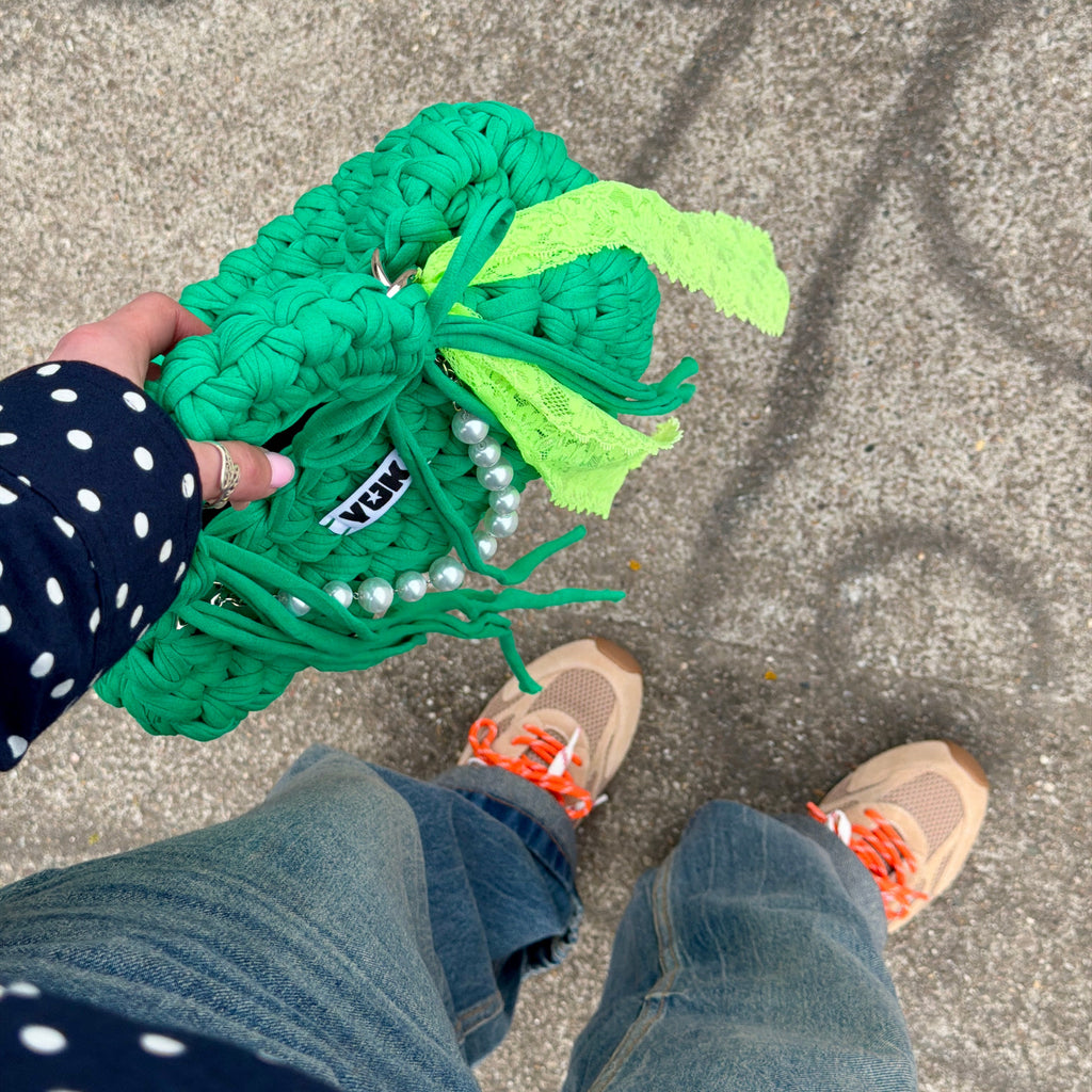 Lifestyle image featuring the green Studio YUK crochet handbag