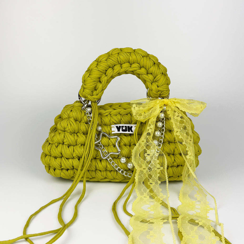 Handmade crochet handbag in green and yellow with lace detail and a bag charm by Studio YUK