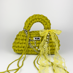Handmade crochet handbag in green and yellow with lace detail and a bag charm by Studio YUK