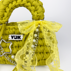 Handmade crochet handbag in green and yellow with lace detail and a bag charm by Studio YUK