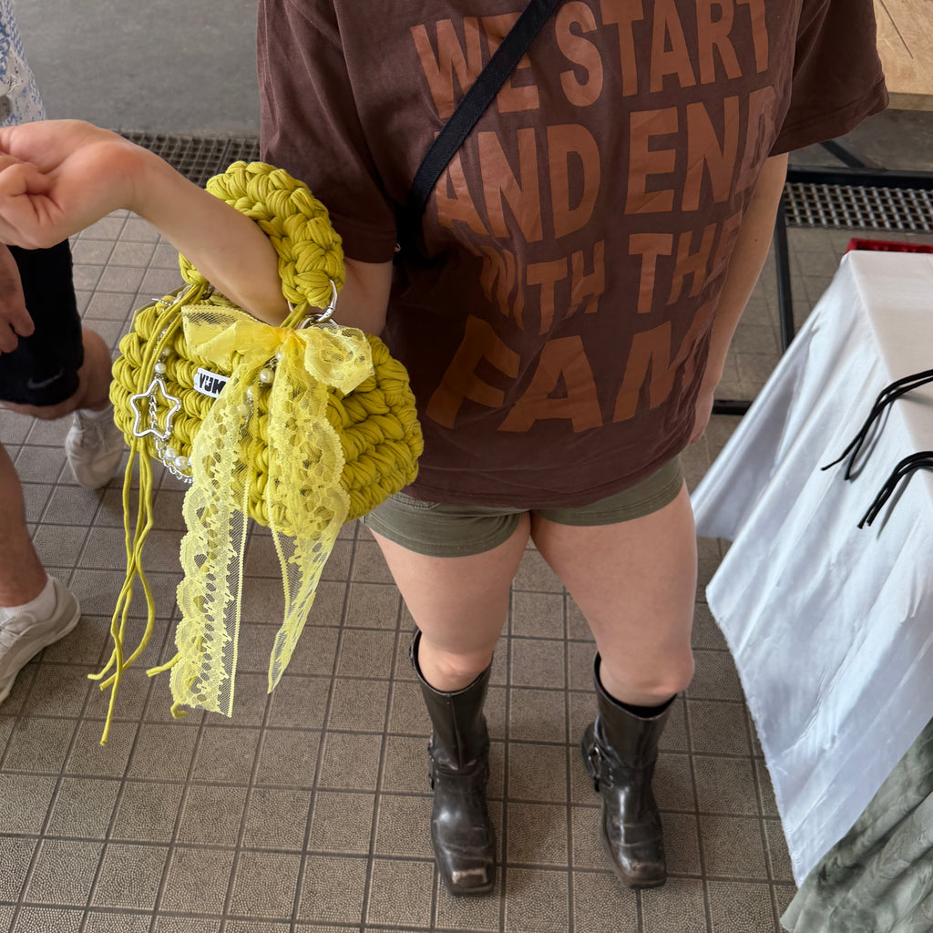 Lifestyle image featuring the green and yellow Studio YUK crochet handbag