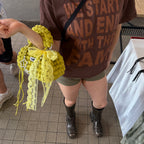 Lifestyle image featuring the green and yellow Studio YUK crochet handbag