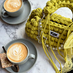 Lifestyle image featuring the green and yellow Studio YUK crochet handbag