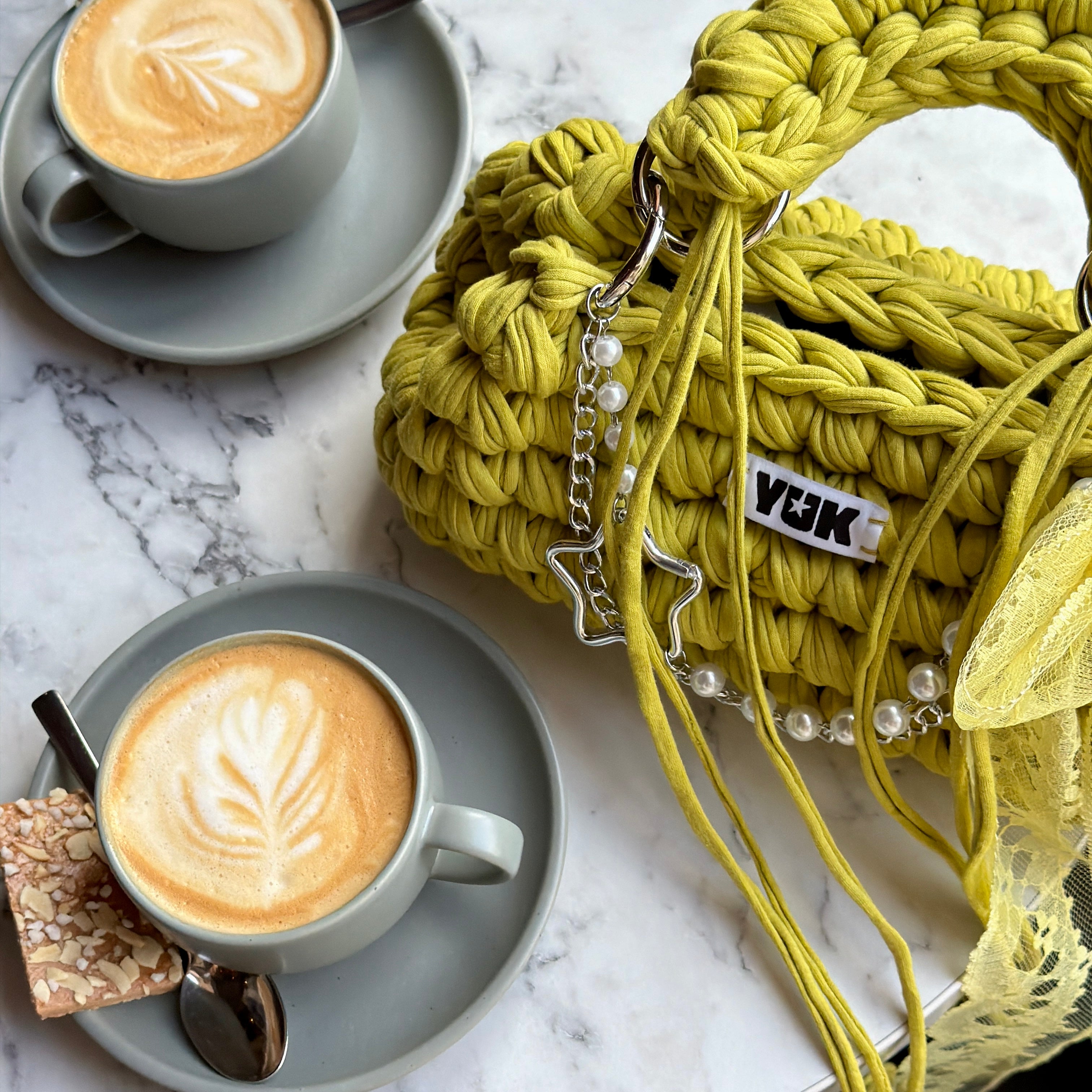 Lifestyle image featuring the green and yellow Studio YUK crochet handbag