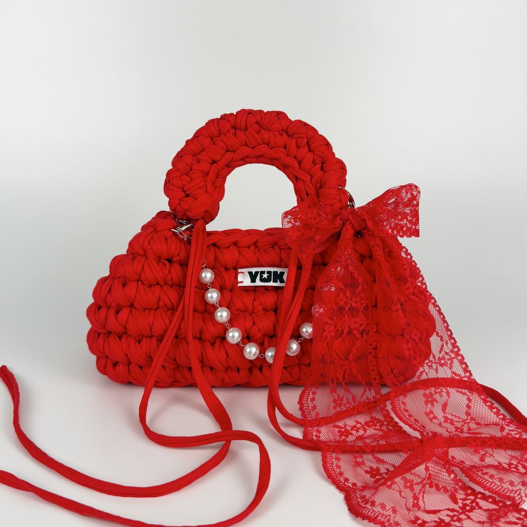Handmade crochet handbag in red with lace detail and a bag charm by Studio YUK