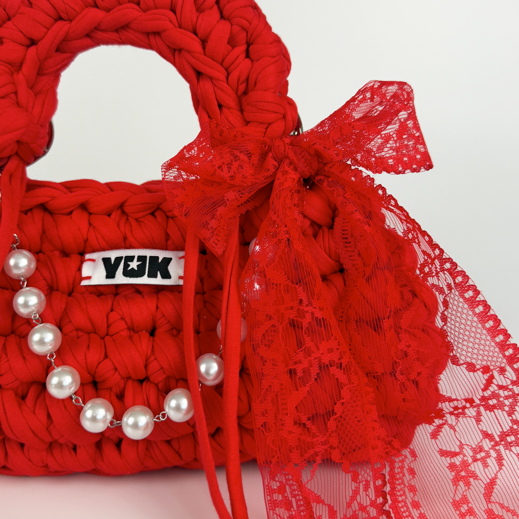 Handmade crochet handbag in red with lace detail and a bag charm by Studio YUK