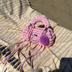 Handmade crochet handbag in pink with pompom detail and a bag charm by Studio YUK